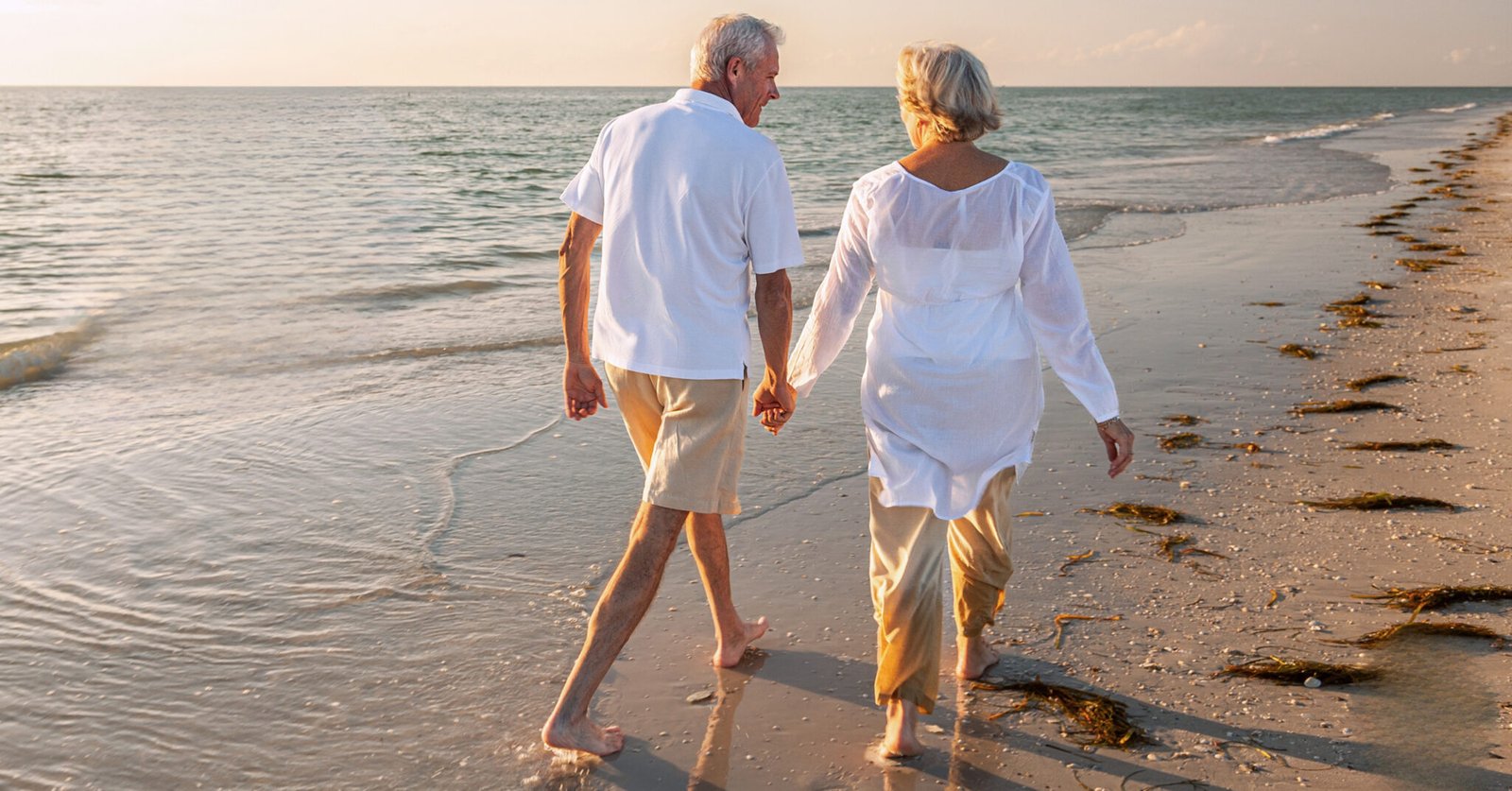 An elderly couple is strolling along the beach at the Baltic Sea resort of Damp as the sun sets.