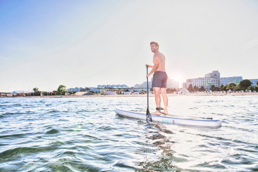 Ein Mann beim Paddeln im Ostsee Resort Damp, einem Wellness-Urlaubsziel.