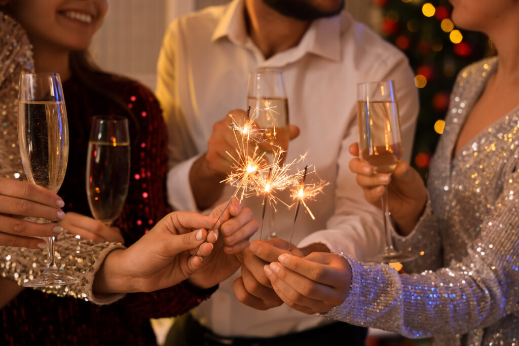 Weihnachts_party.jpg: Festliche Torsi mit Wunderkerzen, Champagner, Weihnachtsbaum.