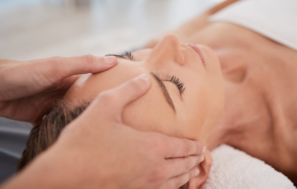 Weekend_relax_wellness_ostsee_massage: Person genießt Stirnmassage, Handtuch unter dem Kopf.