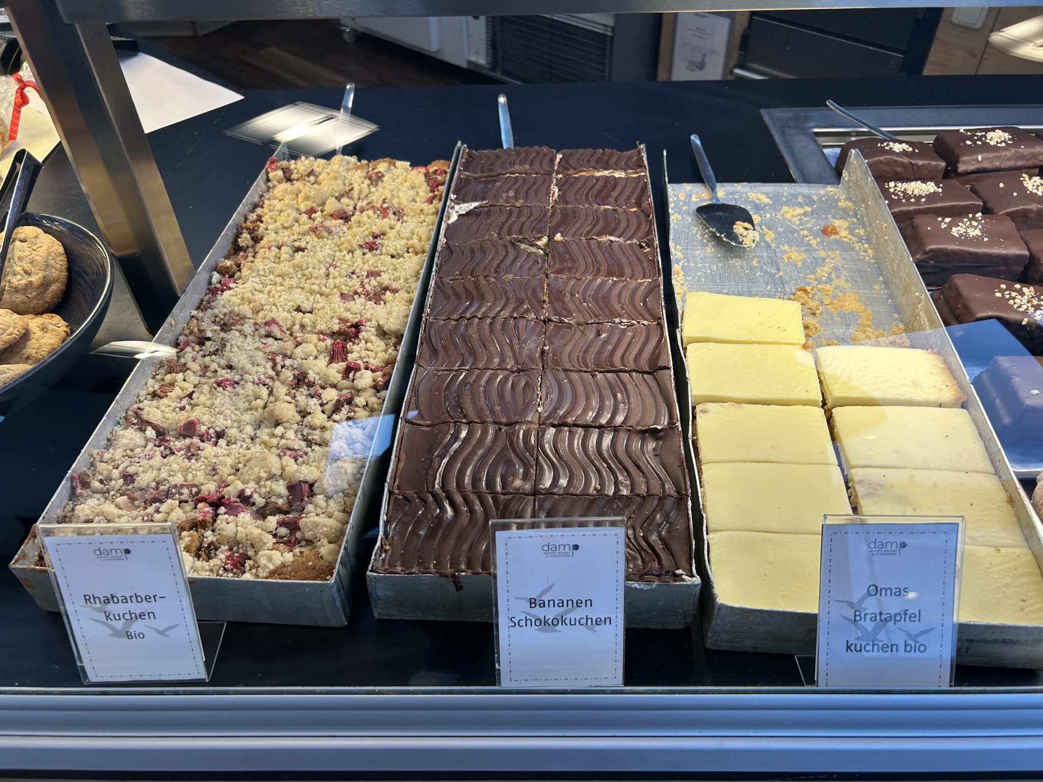 Spitzbergen_kuchenbuffet: Drei beschriftete Kuchen in der Backstube, fein säuberlich ausgestellt.