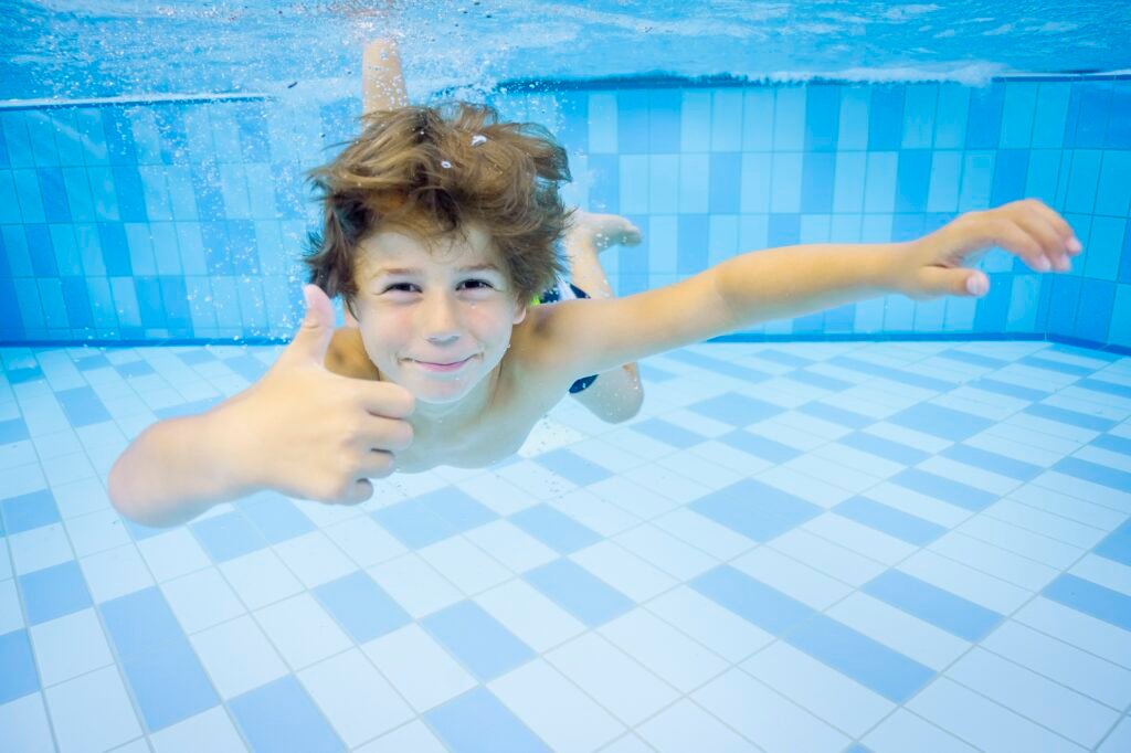 Ein Junge schwimmt unter Wasser im Urlaubsort Ostsee Resort Damp.