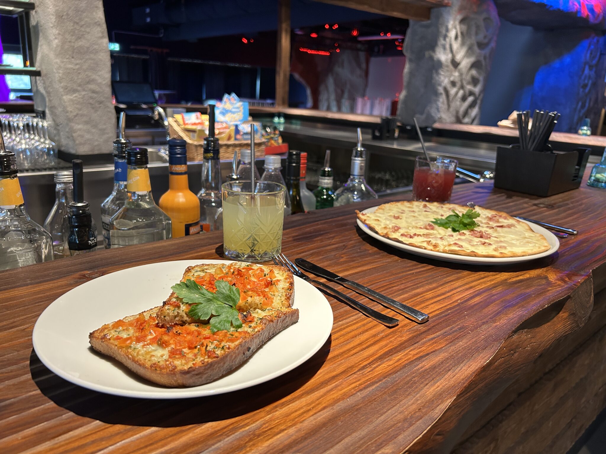 Feiertags-Bar-Theke.jpg: Getränke, vegetarischer Toast, Pizza, Schnapsflaschen auf dem Tresen.