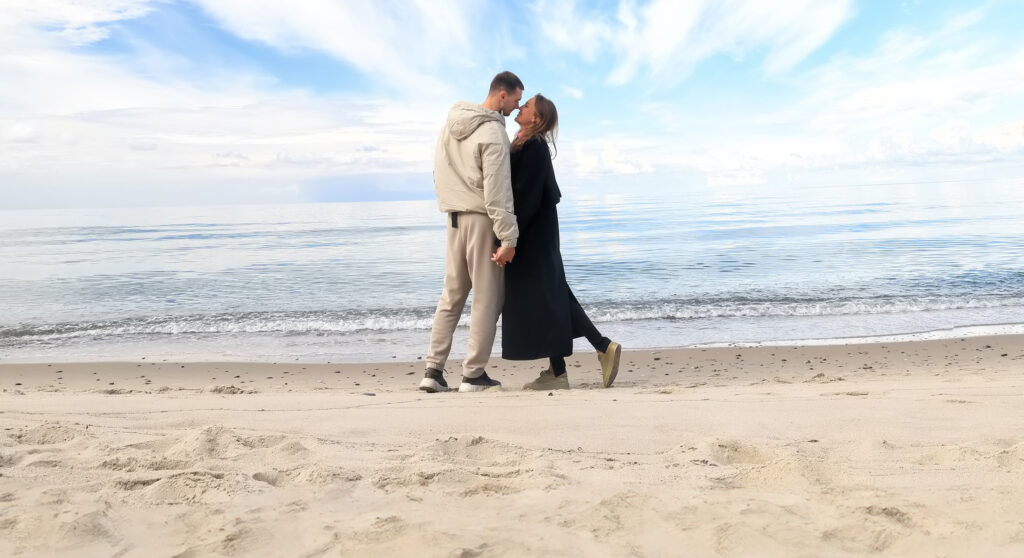 Paar hält sich am Strand an den Händen und berührt sich an der Stirn-ostsee_resort.jpg.