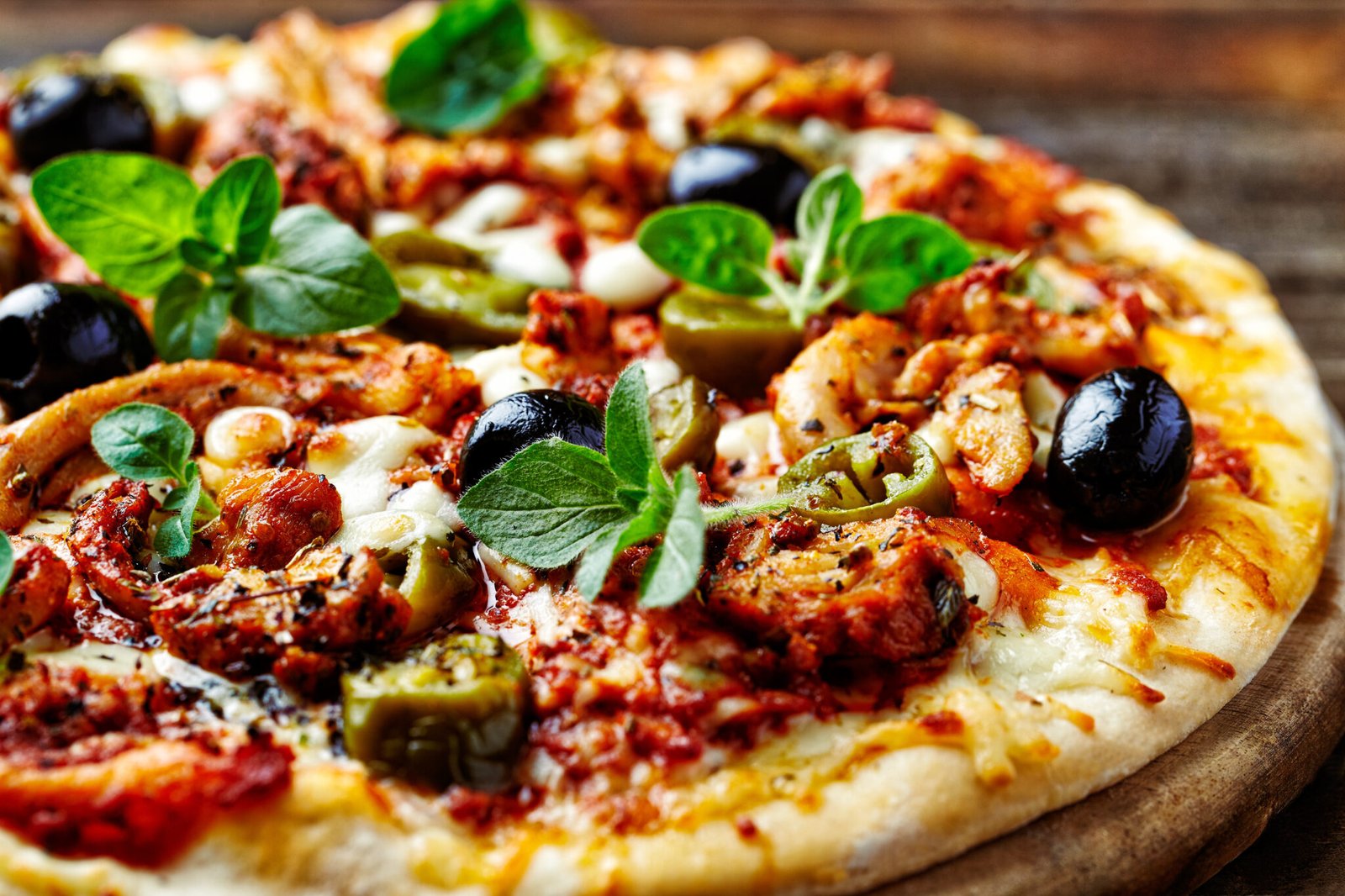 Pizza_baywatch: Pizza mit Oliven, Huhn, Paprika und Käse im Bistro.