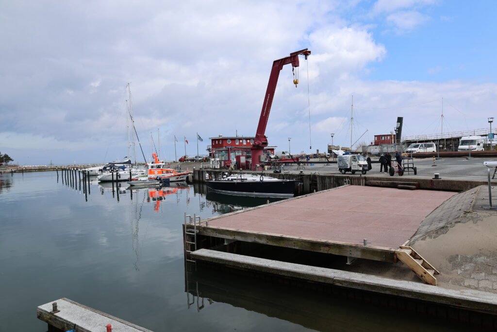 Feuchter Hafen: Boote, Kran, Südstrand, idealer Urlaubsort an der Ostsee.