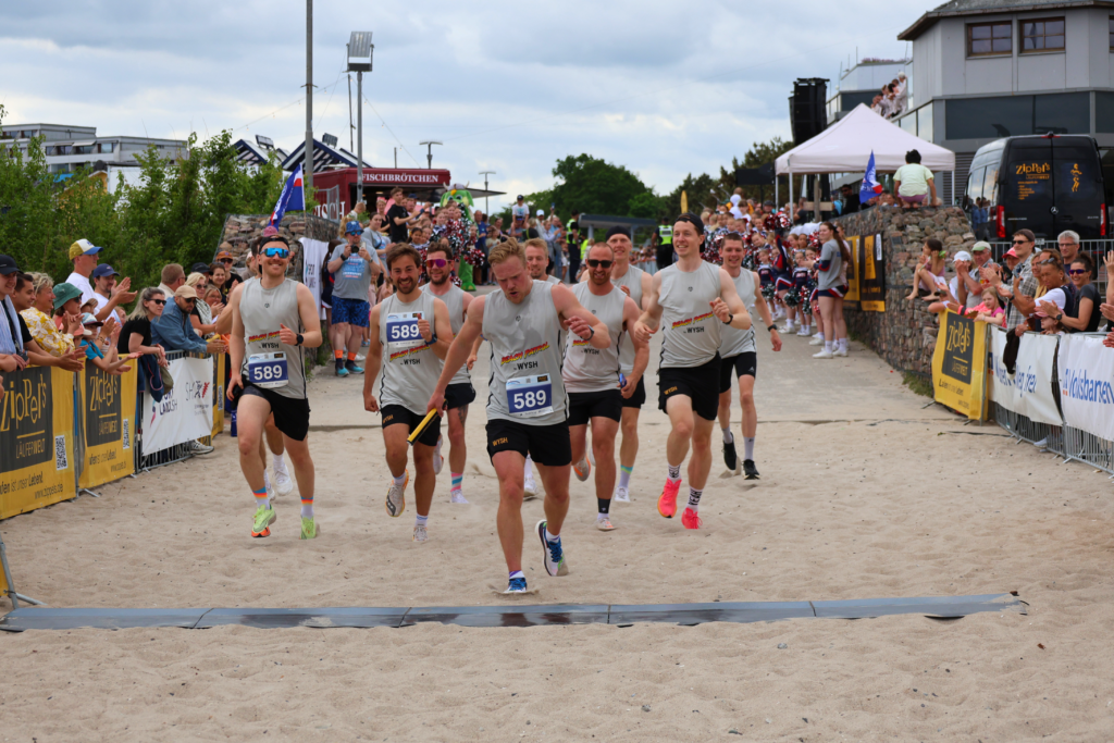 Läufer laufen auf dem Sand in der Nähe des Ostsee-Resorts Damp, einem Urlaubsziel.