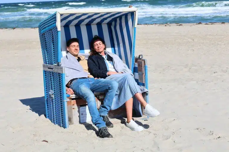 Ein Paar kuschelt sich unter einem Strandvordach im Ostsee Resort Damp.