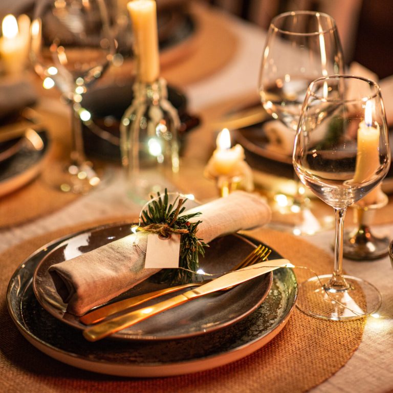 winter holidays, dinner party and celebration concept - close up of scandinavian christmas table serving with burning candles at home at night