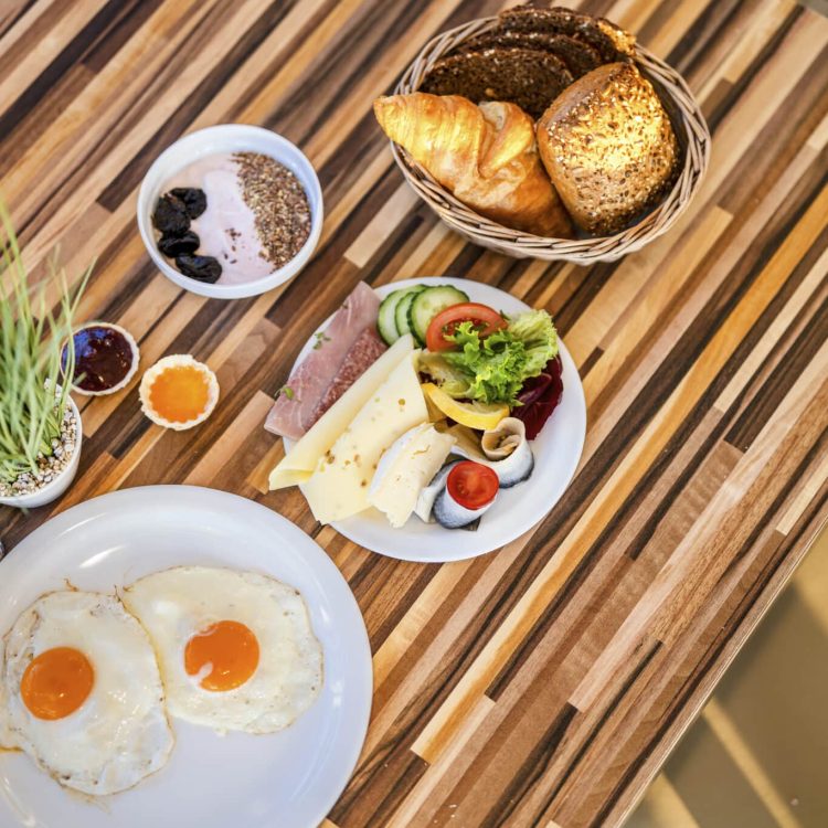 Beginnen Sie Ihren Tag am Meer: Frühstück im Hotel mit Eiern, Brot und Obst.