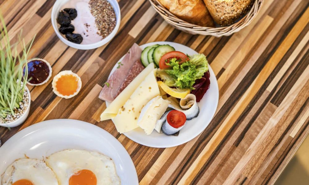 Beginnen Sie Ihren Tag am Meer: Frühstück im Hotel mit Eiern, Brot und Obst.