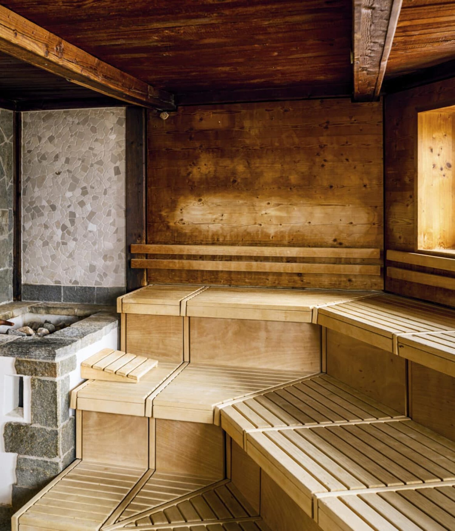 Holzsauna mit Bänken, Fenster und Ofen - ideal zum Entspannen nach dem Schwimmen.