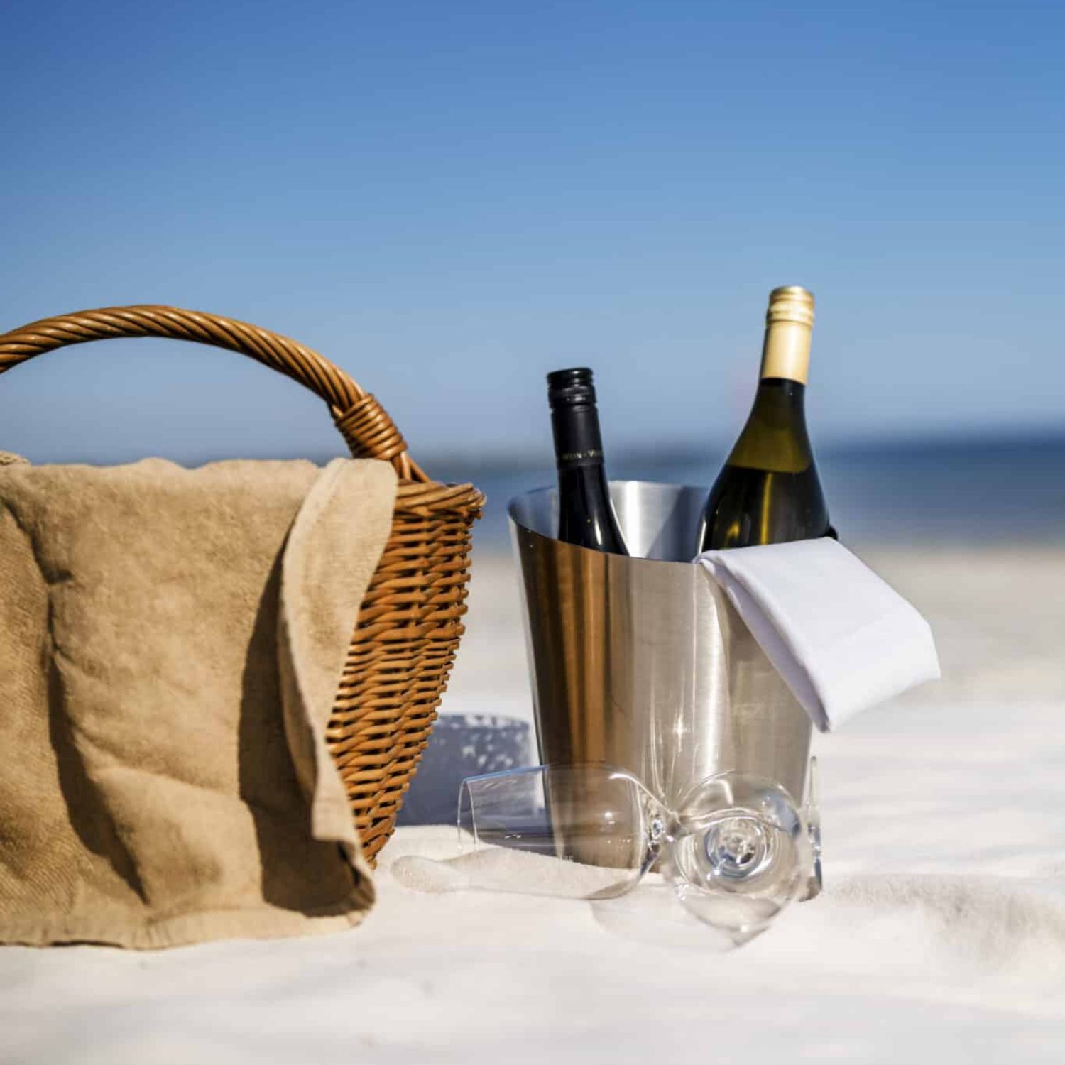 Weidenkorb, Wein und Gläser warten auf ein romantisches Ostsee-Strandpicknick.