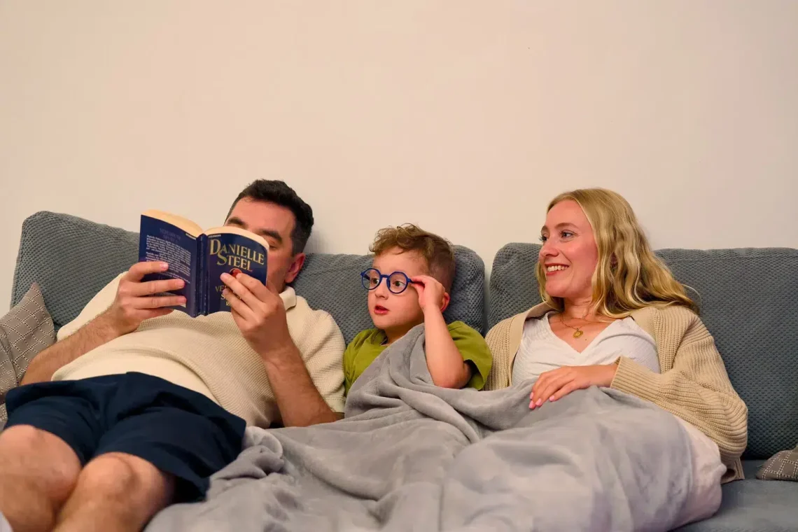 Die Familie liest gemütlich unter einer Decke im Ostsee Resort Damp.