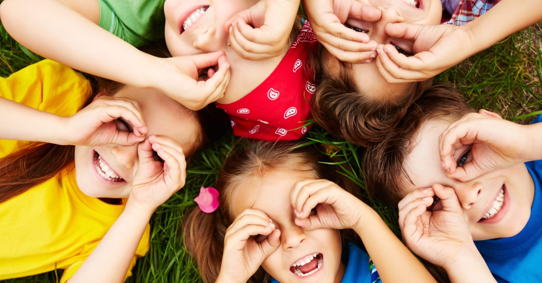Group of cute children lying on grass